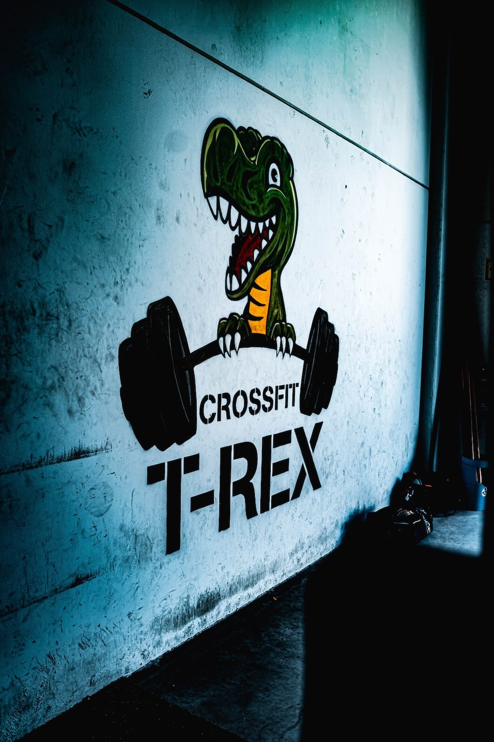 El dinosaurio de CrossFit T-Rex pintado en la pared del box