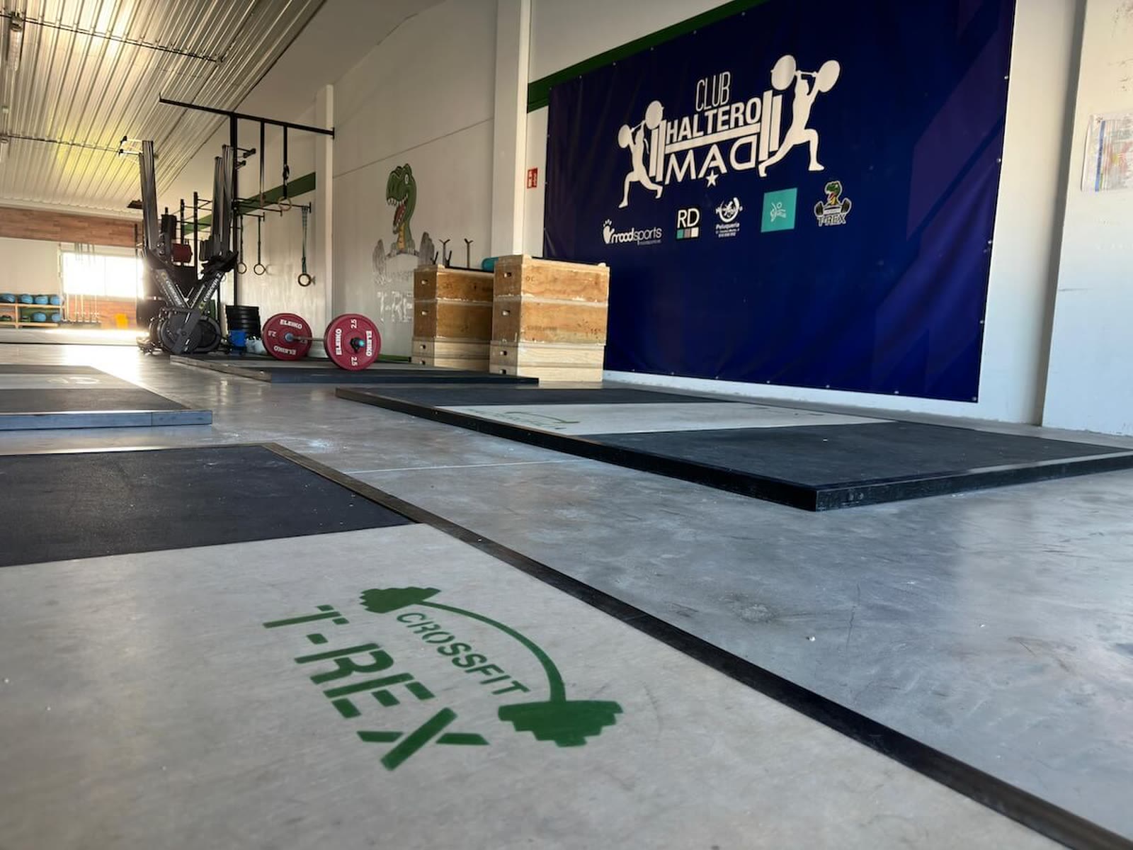 Interior de la nave con el logo de CrossFit T-Rex estarcido en el suelo